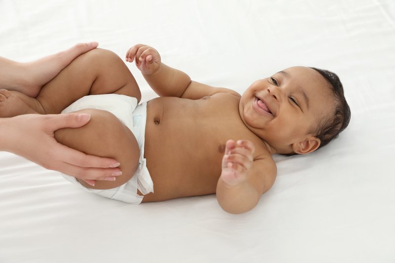 Close-up of laughing baby lying on bed