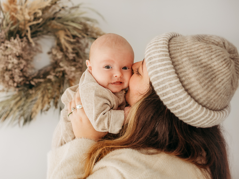 Mum kissing cheek of her baby boy born through fertility treatment with Essential Fertility